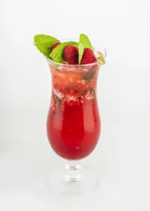A colorful layered mocktail with a mix of juices and a garnish.
