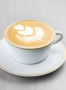 A cup of espresso and steamed milk topped with a thin layer of foam.