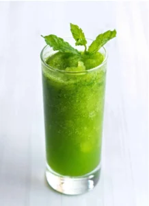 A refreshing glass of cloudy yellow lemonade garnished with fresh mint leaves.