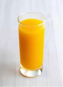 A glass of vibrant orange juice with a pulp-free appearance.