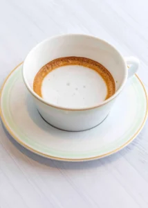 A small cup with a double shot of espresso topped with a dollop of milk foam.